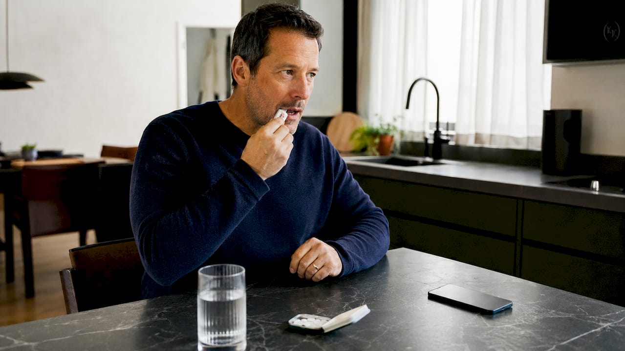 Man applying nicotine gel at kitchen table