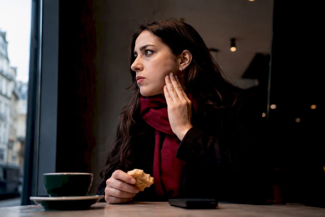 Woman touching jaw after chewing