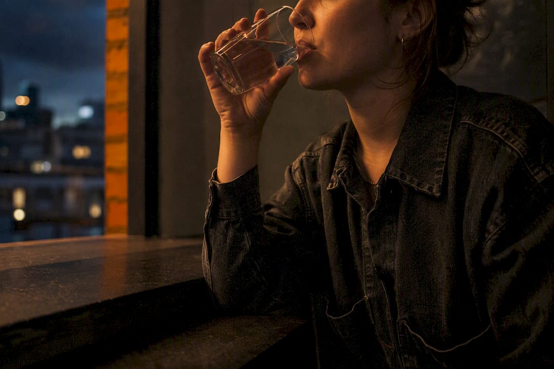Woman sipping water after nicotine aftertaste